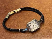 Front view of Wittnauer 14kt watch on black cord bracelet