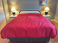 Bed with white and black headboard, two nightstands flanking bed