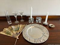 All items grouped on table: pewter tray, two crystal candle holders, two white candles, bud vase, two coupe glasses not listed, one pewter candle holder, painted fan