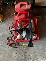 Gas cans and crate with contents on floor