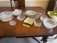 All glass items arranged on table showing overall lot