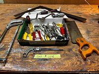 overview of lot on workbench, showing saws, brace, squares and box of tools