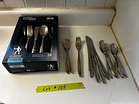 Boxed 20-piece flatware set next to loose utensils