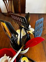 Utensils grouped in container showing variety of spatulas, spoons, scraper and wooden pieces