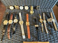All eleven watches laid out showing cases, straps and loose heads