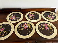 Set of six round Pimpernel Clematis placemats displayed