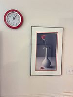 Wall view showing red bezel clock and framed rose print