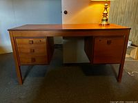 Front view showing teak desk, left three-drawer pedestal, right file drawer pedestal