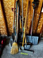 Group view of all long-handled tools leaning against wall