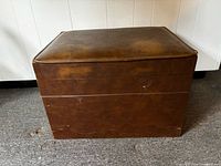 Full view of brown leather footstool closed
