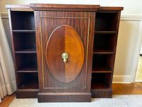Full front view of walnut cabinet showing central door and side shelves
