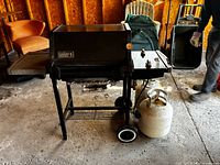 Full view of Weber gas grill with propane tank attached