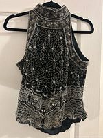 Rear view of black silk beaded halter top on hanger