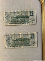 Both one-dollar notes reverse side showing Parliament Buildings