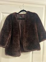Front view of faux fur jacket on hanger