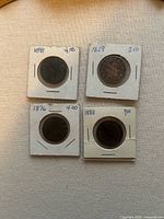 Four coin holders showing dates 1898, 1859, 1876, 1888