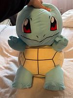 Front view of large Squirtle plush showing face, torso, limbs