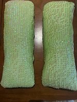 Front view showing light green sequined surfaces of both pillows