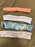 Four Lululemon headbands laid flat showing logos and colour patterns