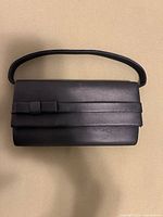Front view of black evening purse with bow detail