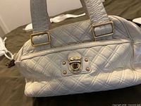 Front view showing quilted pattern, gold-tone push-lock and handles