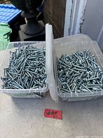 Both plastic boxes filled with screws side by side