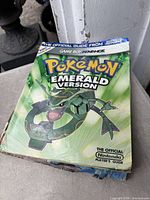 Cover of Pokémon Emerald Version Official Nintendo Player’s Guide showing Rayquaza artwork and worn corners