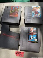 Top view of three NES cartridges: Donkey Kong Classics, Super Mario Bros. 2, Super Mario Bros./Duck Hunt with a Nintendo dust sleeve visible
