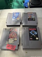 Four NES game cartridges laid out on surface showing labels and overall wear