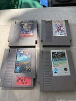 Front view of four Nintendo NES cartridges: Tecmo Super Bowl, Blades of Steel, Pro Wrestling, Rad Racer