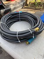 Coiled grey hose showing brass connector and blue grip sleeve