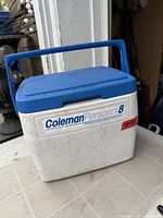 Front view of Coleman Personal 8 cooler showing lid, handle, and logo