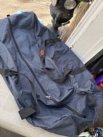 Full view of blue nylon duffle bag showing zipper and handles