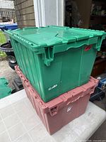 Stacked green and brown lockable plastic totes with fold-in lids