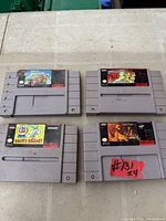 All four SNES cartridges laid out showing labels and wear