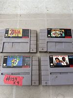 All four SNES game cartridges laid out showing front labels and overall wear