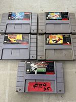 All five SNES game cartridges laid out showing front labels and overall wear