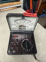 Open view of Micronta 22-211 folding analog multimeter showing meter scale, rotary selector and jacks