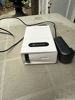 Front view of mini projector and power adapter