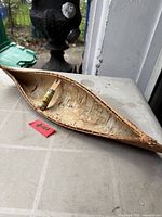 Side view of birch bark canoe showing interior and lashings