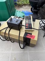 Nintendo NES console with one controller and AC adapter visible