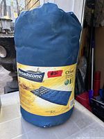 Sleeping bag in blue carry sack showing main product label