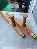 Two matching wooden tonfa on tabletop showing full length and handles