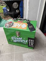 Front view of green Steam Whistle cooler with latch and stickers