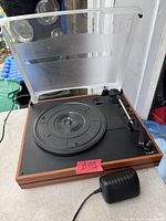 Top view of turntable with dust cover open showing platter, tonearm and woodgrain plinth