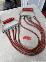 Full view of chest expander showing handles and five tubes