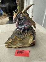 Front view of painted resin dragon coin bank showing overall form and colors