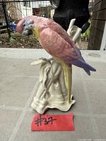 Front view of Karl Ens porcelain parrot figurine on branch base