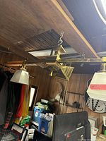 Full view of brass ceiling fixture suspended from chain with two frosted glass shades