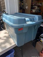 Entire blue Rubbermaid Roughneck storage box on table, lid closed